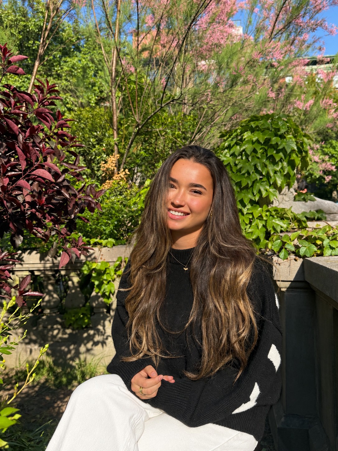 Zoë smiling outdoors in a garden